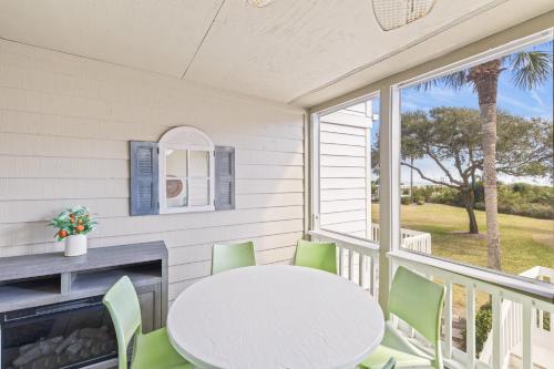 a porch with a white table and chairs and a fireplace at Beach Club Villa 27 - Oceanview Walkout by Beach and Pool in Isle of Palms
