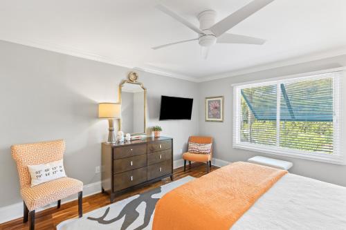 ein Schlafzimmer mit einem Bett, einer Kommode und einem Fenster in der Unterkunft Beach Club Villa 27 - Oceanview Walkout by Beach and Pool in Isle of Palms