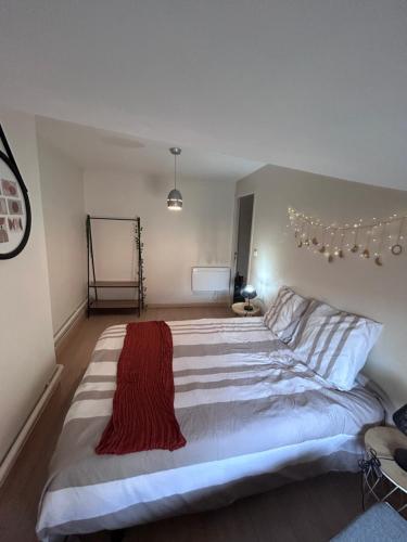 a bedroom with a large bed with a red blanket on it at Terre lyonnaise à l Arbresle in Éveux