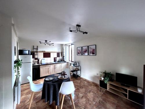a living room with a table and a kitchen at Terre lyonnaise à l Arbresle in Éveux