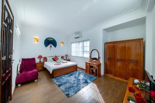 a living room with a bed and a red chair at Hanoi Phoenix Boutique Hotel in Hanoi