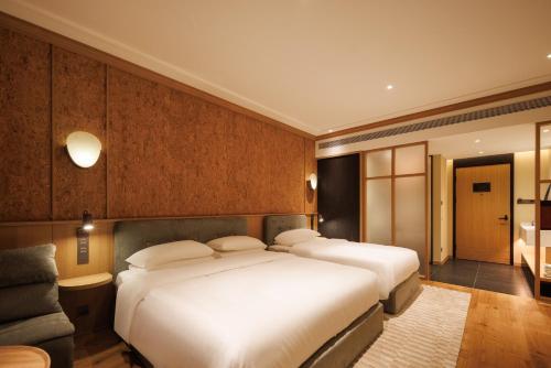 a hotel room with two beds and a couch at Changbai Mountain Lanpu Design Hotel in Antu