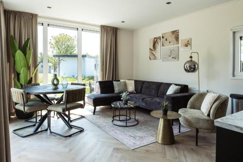 a living room with a couch and a table at Kaag Villas in Warmond