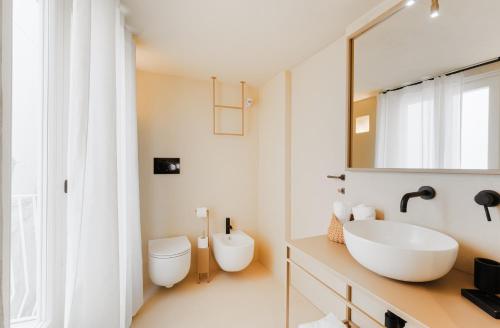 a bathroom with a sink and a toilet and a mirror at NEW OPENING - Palazzo Gasparino Suites in Monopoli