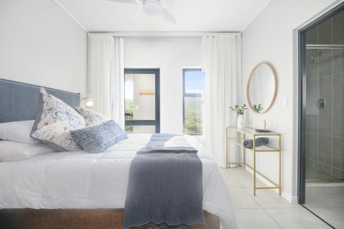 a bedroom with a bed with a mirror and a window at Ballito Hills 824 in Ballito