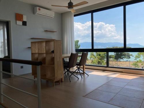 a room with a table and chairs and large windows at Seaview Master Room - Ensuite Bath in Butterworth in Butterworth