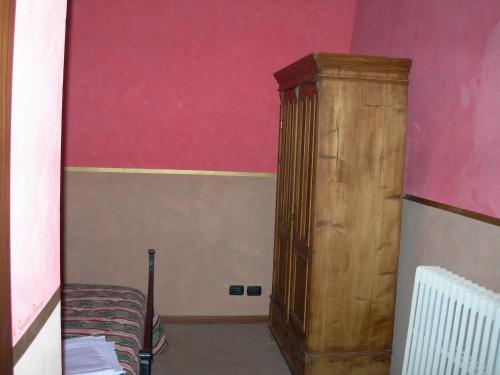 a bedroom with a wooden cabinet next to a bed at Società Agricola F.lli Angelucci in Cannara
