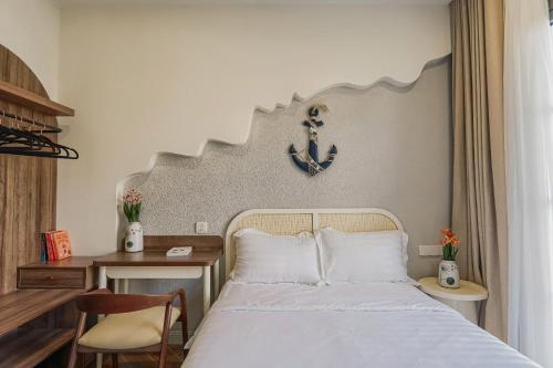 a bedroom with a bed and a clock on the wall at Holiday Villa Novaworld Phan Thiet in Phan Thiet