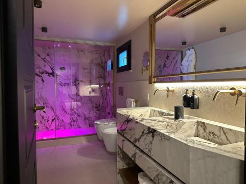 a bathroom with a purple shower and a sink at Torre Argentina Relais - Residenze di Charme in Rome