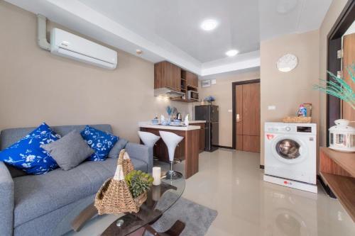 un soggiorno con divano grigio e una cucina di Chic 1BR Condo Steps from Nai Harn S311 a Nai Harn Beach