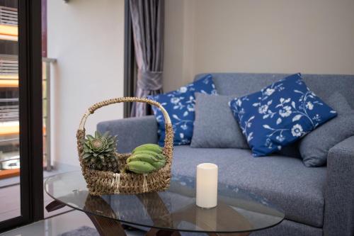 un soggiorno con divano e tavolo con cesto di Chic 1BR Condo Steps from Nai Harn S311 a Nai Harn Beach