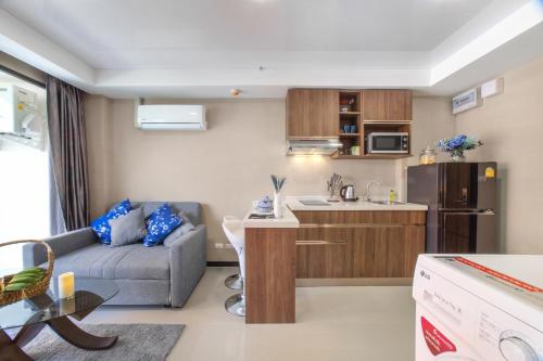a small living room with a couch and a kitchen at NARA Condo 1BR Pool View NBC Nai Harn in Nai Harn Beach
