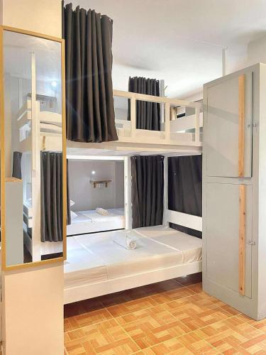a room with white bunk beds with black curtains at Chill Out Hostel in Boracay