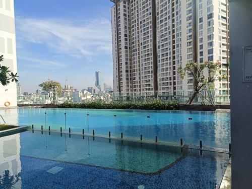 a large swimming pool in a city with tall buildings at DFour River Gate Deluxe Apartment by the River in Ho Chi Minh City