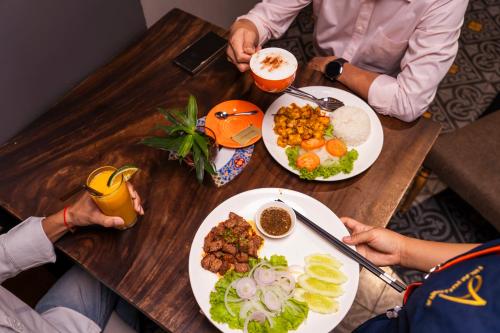 two people sitting at a table with plates of food at Monsoon Bassac Hotel in Phnom Penh