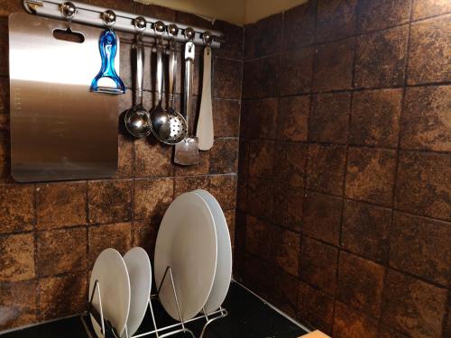 a kitchen with white plates and utensils on a wall at Athasri Hotel Infantry Road in Bengaluru