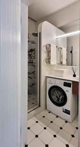 a washing machine in a bathroom with a shower at Violet Lux Apartment in Daugavpils