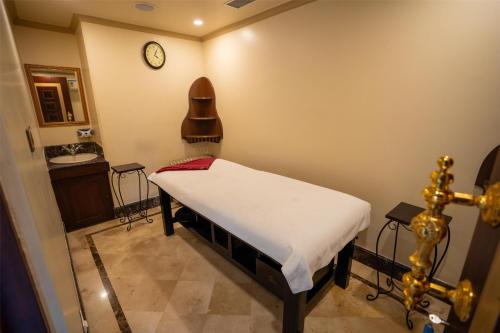a small room with a bed and a clock on the wall at Radisson Hotel Jalandhar in Jalandhar
