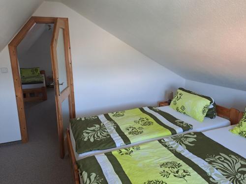 a room with two beds with green blankets and pillows at Villa Joanna in Františkovy Lázně