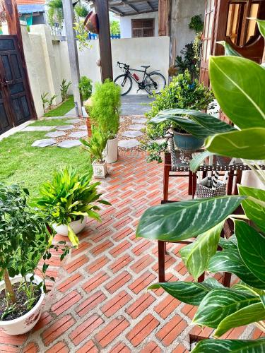a brick patio with potted plants on it at Dốc Lò - Homestay in Phú Hiệp (2)