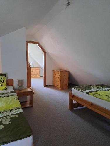 a attic room with two beds and a mirror at Villa Joanna in Františkovy Lázně