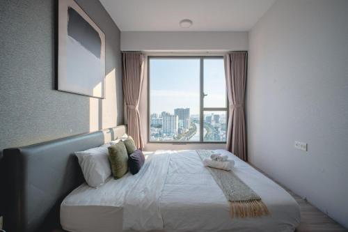 a bedroom with a bed with a large window at DFour River Gate Deluxe Apartment by the River in Ho Chi Minh City