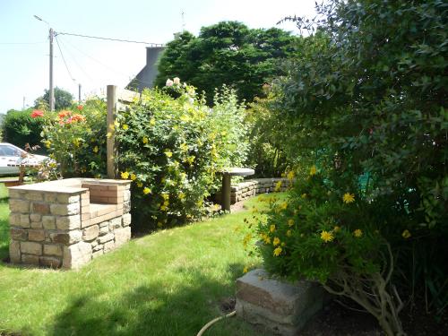 a garden with flowers and a stone wall at Chambre d'hôtes à Lesneven in Lesneven