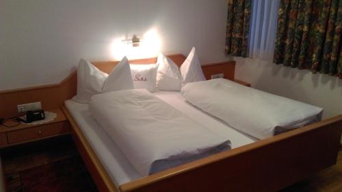 a bedroom with two beds with white sheets and pillows at Gasthof Zum Stollhofer in Inzing