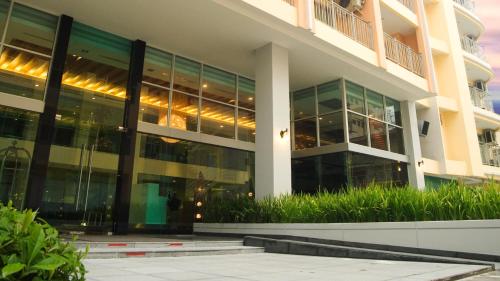 an office building with glass windows and plants at Olive Hotel & Residence Bangkok Sukhumvit 101 in Bangkok