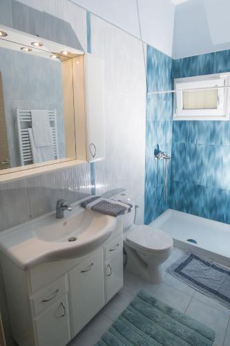 a bathroom with a sink and a toilet and a mirror at Corfu Erimitis in Ágios Stéfanos