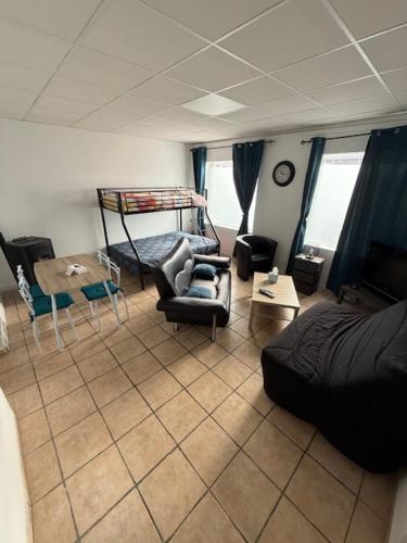 a living room with a couch and a bed at Appartement dans maison au calme in Forbach