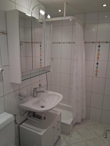 a bathroom with a sink and a toilet and a mirror at La Prada - 2 Zimmerwohnung mit 40m2 für max. 3 Personen in Laax