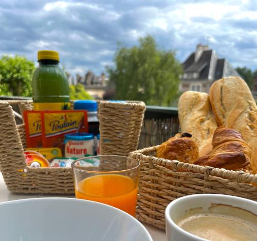 une table avec des paniers de pain et un verre de jus d'orange dans l'établissement Maison familiale Blois piscine et SPA, à Blois