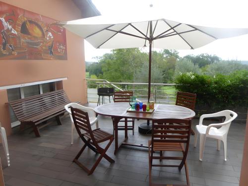 a patio with a table and chairs and an umbrella at Gite Lou Haou in Nassiet