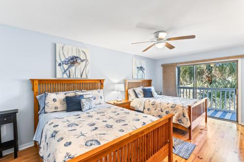 a bedroom with two beds and a ceiling fan at Lagoon Villa 25 - Heart of Wild Dunes, Quick Walk to Beach in Isle of Palms