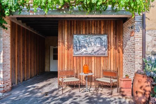 a patio with two chairs and a table and a painting at Le Ali Del Frassino in Peschiera del Garda