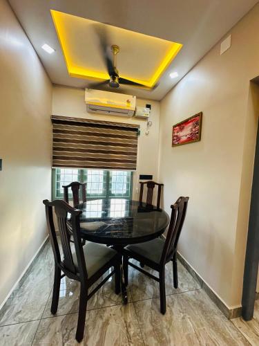 a dining room with a glass table and chairs at North paradise in Cochin