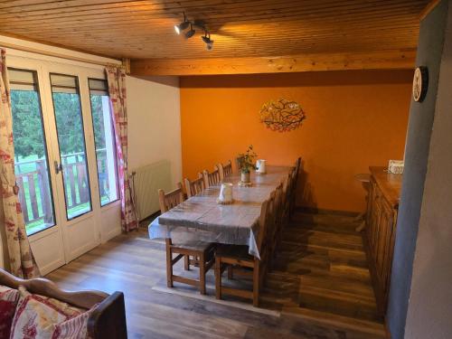a dining room with a long table and chairs at Gîte Le Lac à La Dame in Foncine-le-Bas