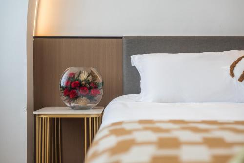 a bed with a vase of flowers on a side table at 尚品9号海景民宿Seaview Hotel in Xiamen