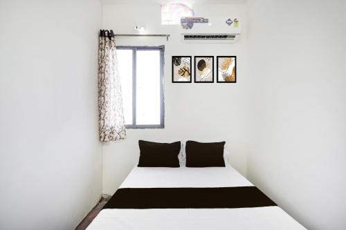a bedroom with a white bed with black pillows at SPOT ON Ap Logde in Māharjhari