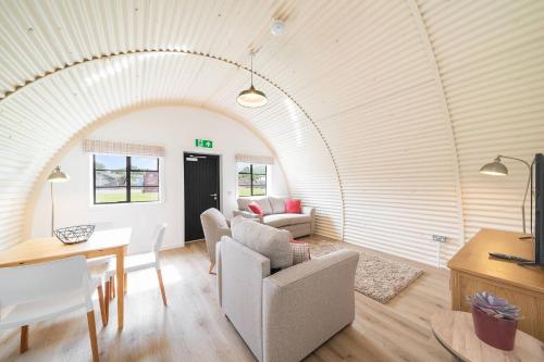a living room with an archway in a house at Cultybraggan Hut 36 in Mill of Fortune