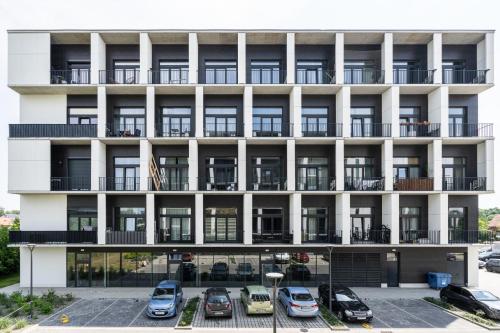 an apartment building with cars parked in the parking lot at Sleep & Fly & Stay Comfort Apartament in Wrocław