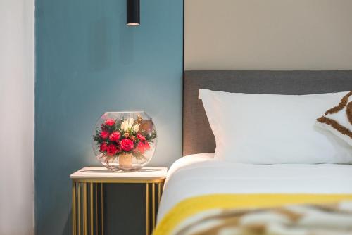 a bedroom with a bed and a vase with flowers in it at 尚品9号海景民宿Seaview Hotel in Xiamen