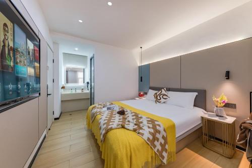a bedroom with a large bed with a yellow blanket at 尚品9号海景民宿Seaview Hotel in Xiamen