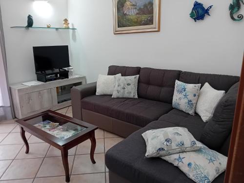 a living room with a couch and a coffee table at Sole Mare di Barbara in Chia