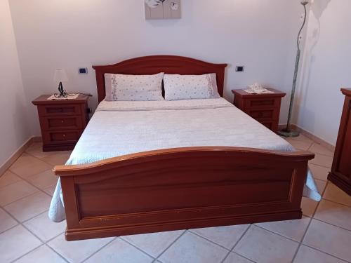 a bedroom with a large wooden bed with two night stands at Sole Mare di Barbara in Chia