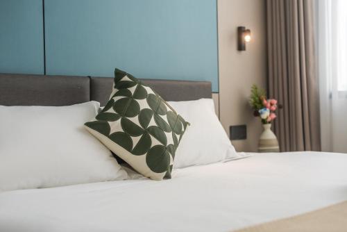 a bed with two pillows on top of it at 尚品9号海景民宿Seaview Hotel in Xiamen