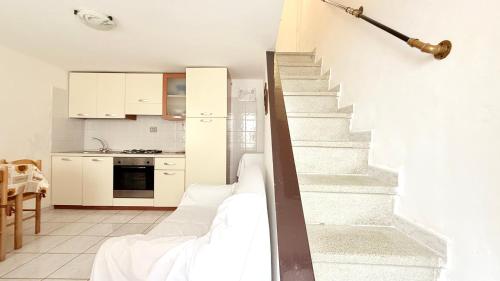 a white kitchen with a staircase in a house at N079 - Numana, delizioso cielo-terra nel centro storico in Numana