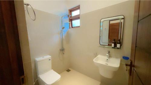 a bathroom with a toilet and a sink and a mirror at Canberra Holidays - Mirissa in Mirissa