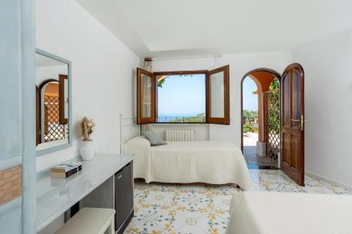 a bedroom with a bed and a window and a mirror at Hotel Il Girasole in Anacapri